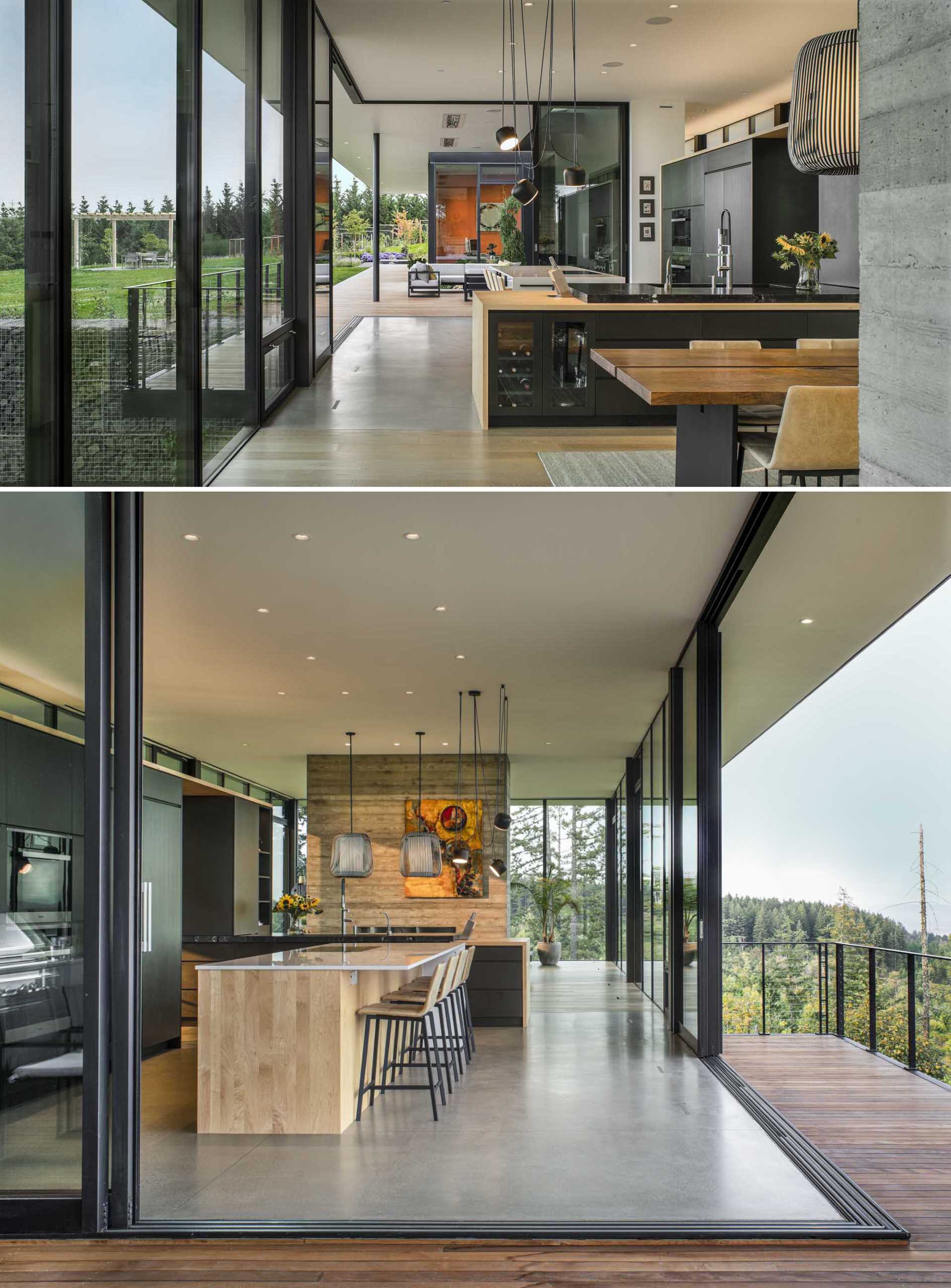 In this modern kitchen, the floors change from wood to polished concrete, while the black cabinets complement the black window frames.